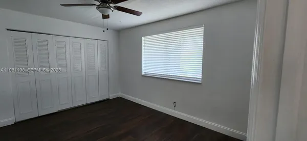 an empty room with a window and a ceiling fan
