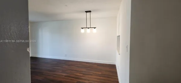 a view of a room with wooden floor and white wall