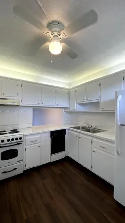 a kitchen with granite countertop stainless steel appliances a stove and cabinets
