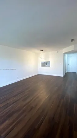a kitchen with granite countertop wooden floors and white stainless steel appliances