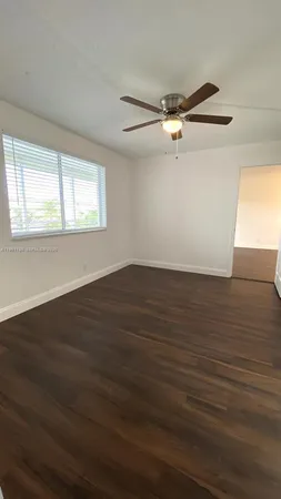 an empty room with wooden floor and door