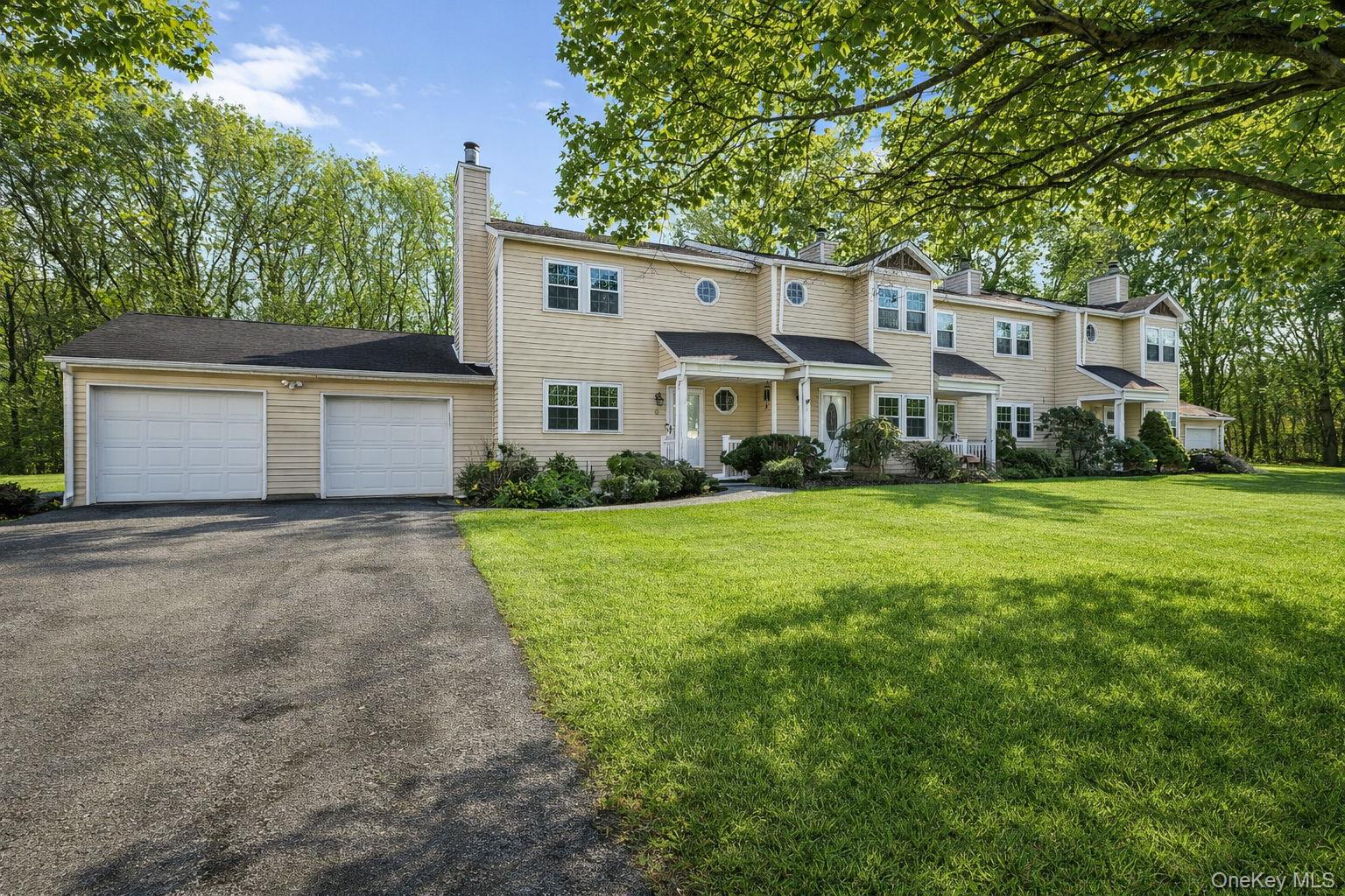a front view of a house with a yard and trees