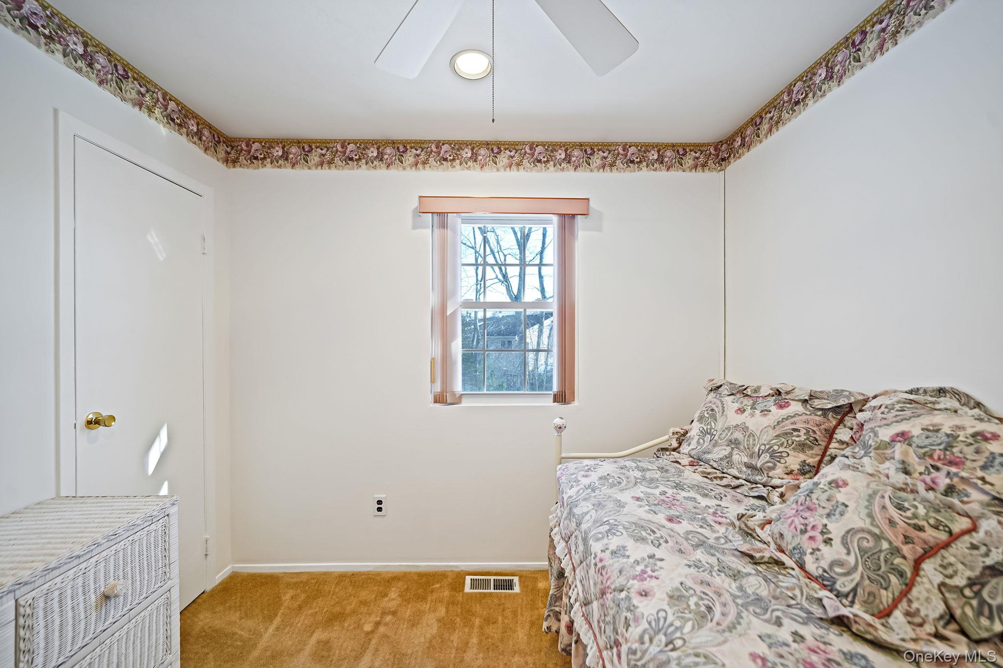 8 Huntington Commons, Unit 8 Yaphank, NY 11980 - Photo 11 of 30 a bedroom with a bed and a window