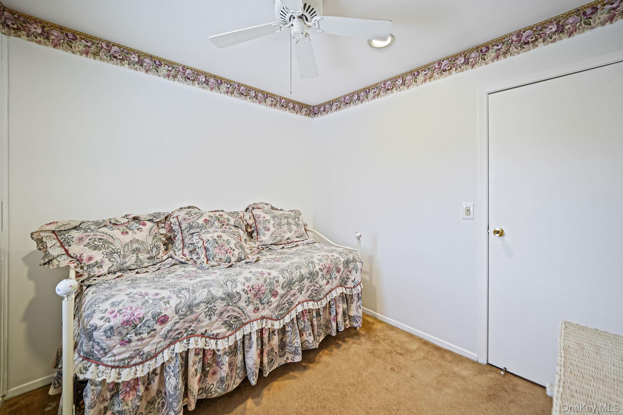 8 Huntington Commons, Unit 8 Yaphank, NY 11980 - Photo 12 of 30 a bedroom with a bed and a chandelier