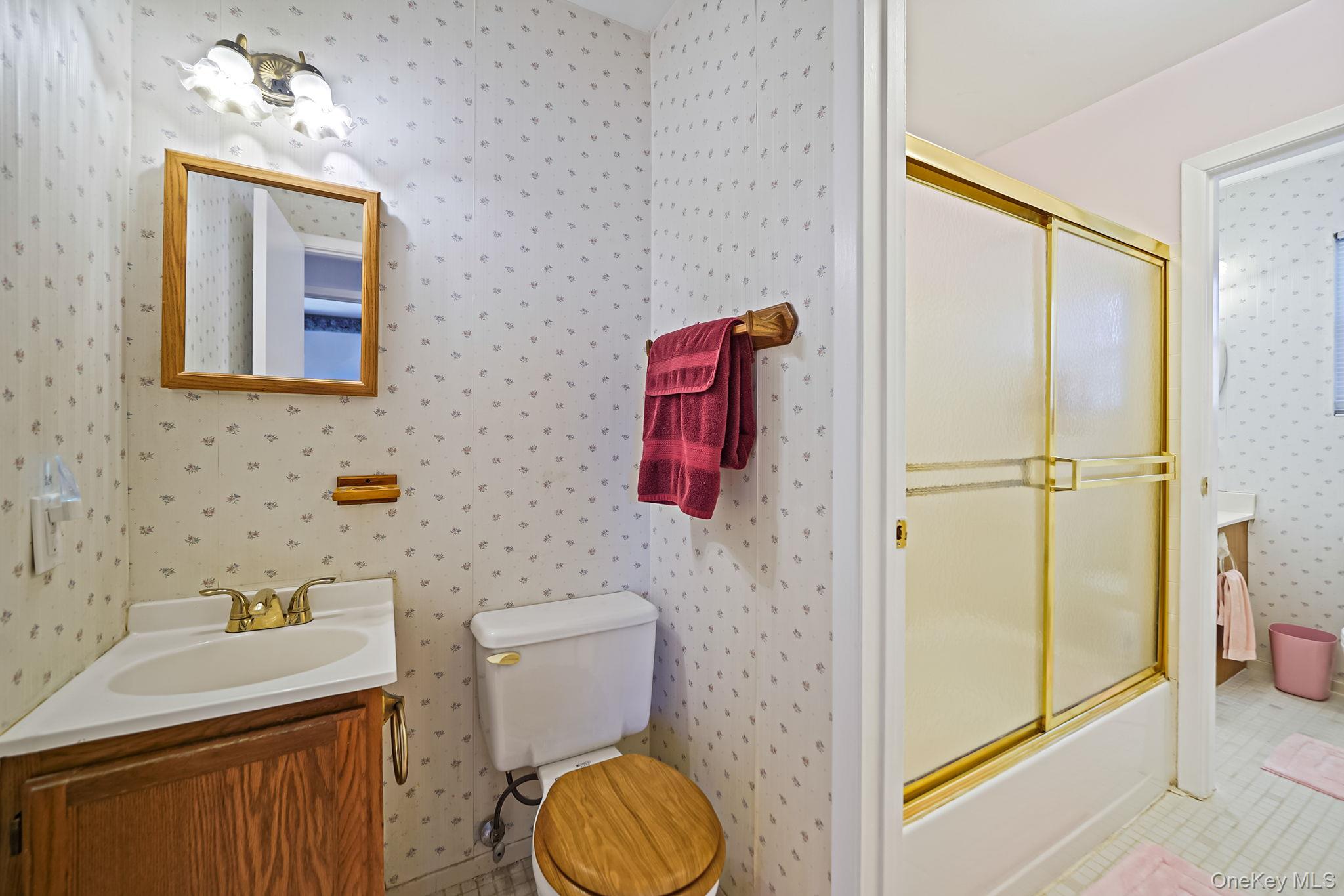 8 Huntington Commons, Unit 8 Yaphank, NY 11980 - Photo 16 of 30 a bathroom with a toilet sink vanity and mirror
