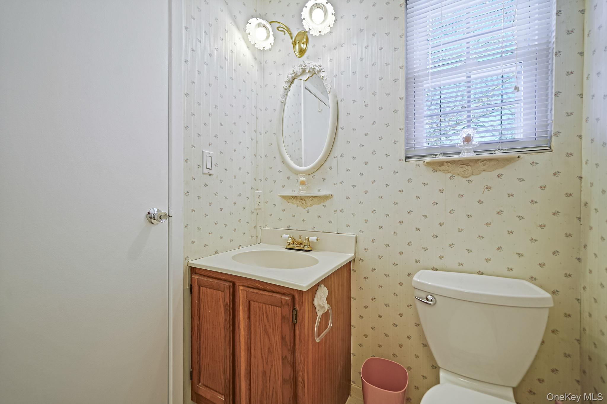8 Huntington Commons, Unit 8 Yaphank, NY 11980 - Photo 18 of 30 a bathroom with a toilet sink and mirror