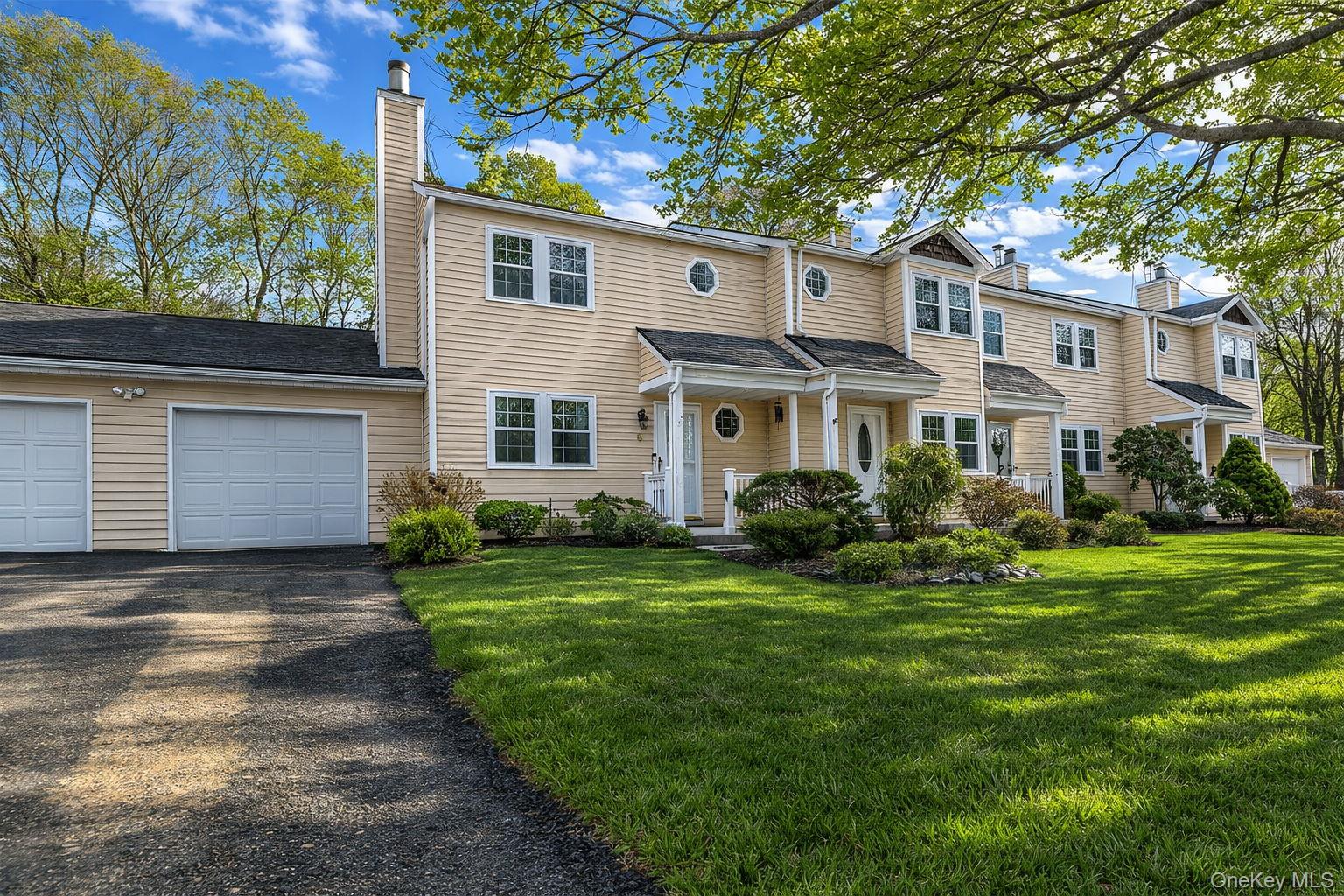 8 Huntington Commons, Unit 8 Yaphank, NY 11980 - Photo 2 of 30 a front view of a house with a yard