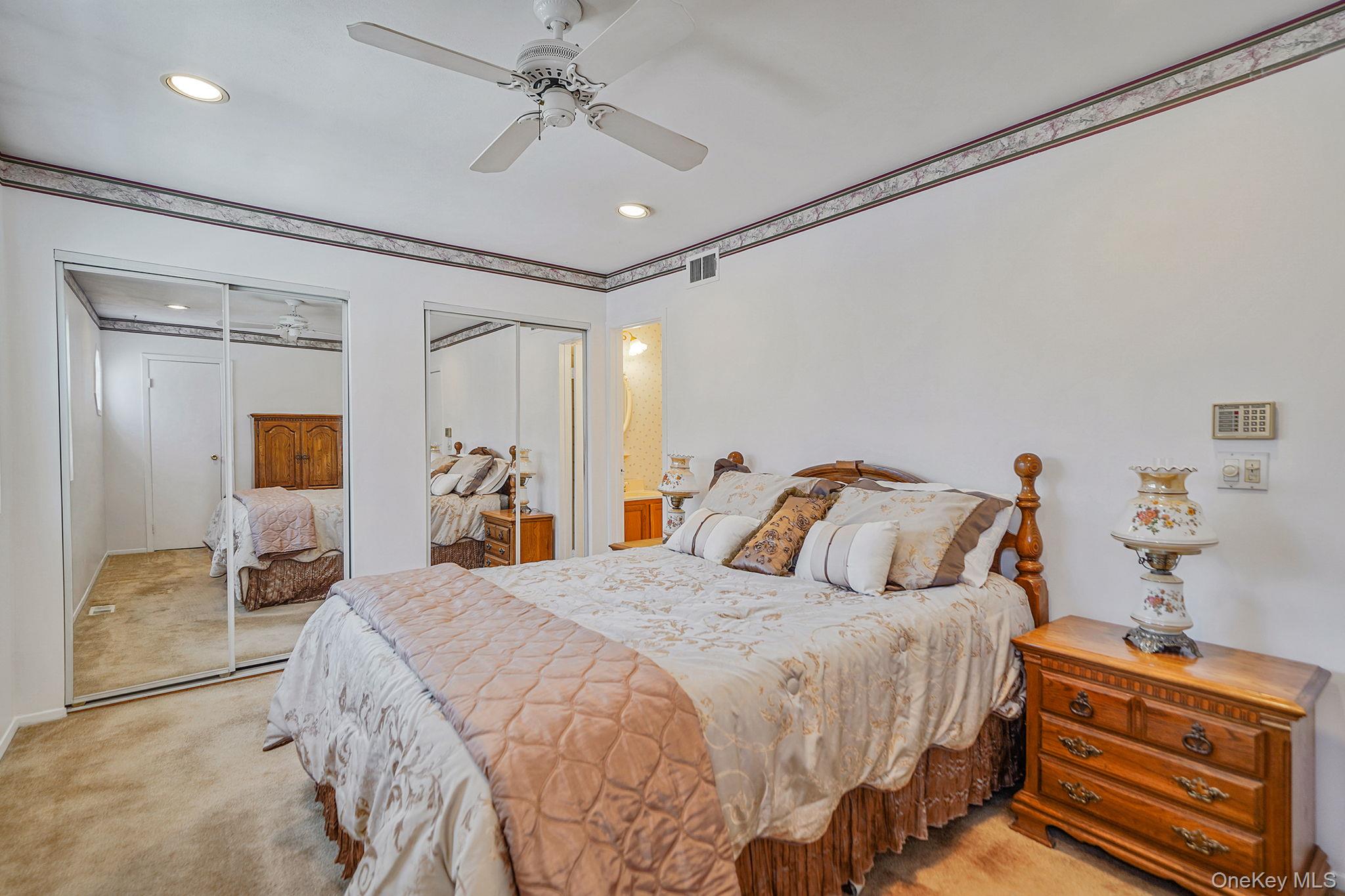 8 Huntington Commons, Unit 8 Yaphank, NY 11980 - Photo 21 of 30 a bedroom with a bed and a chandelier