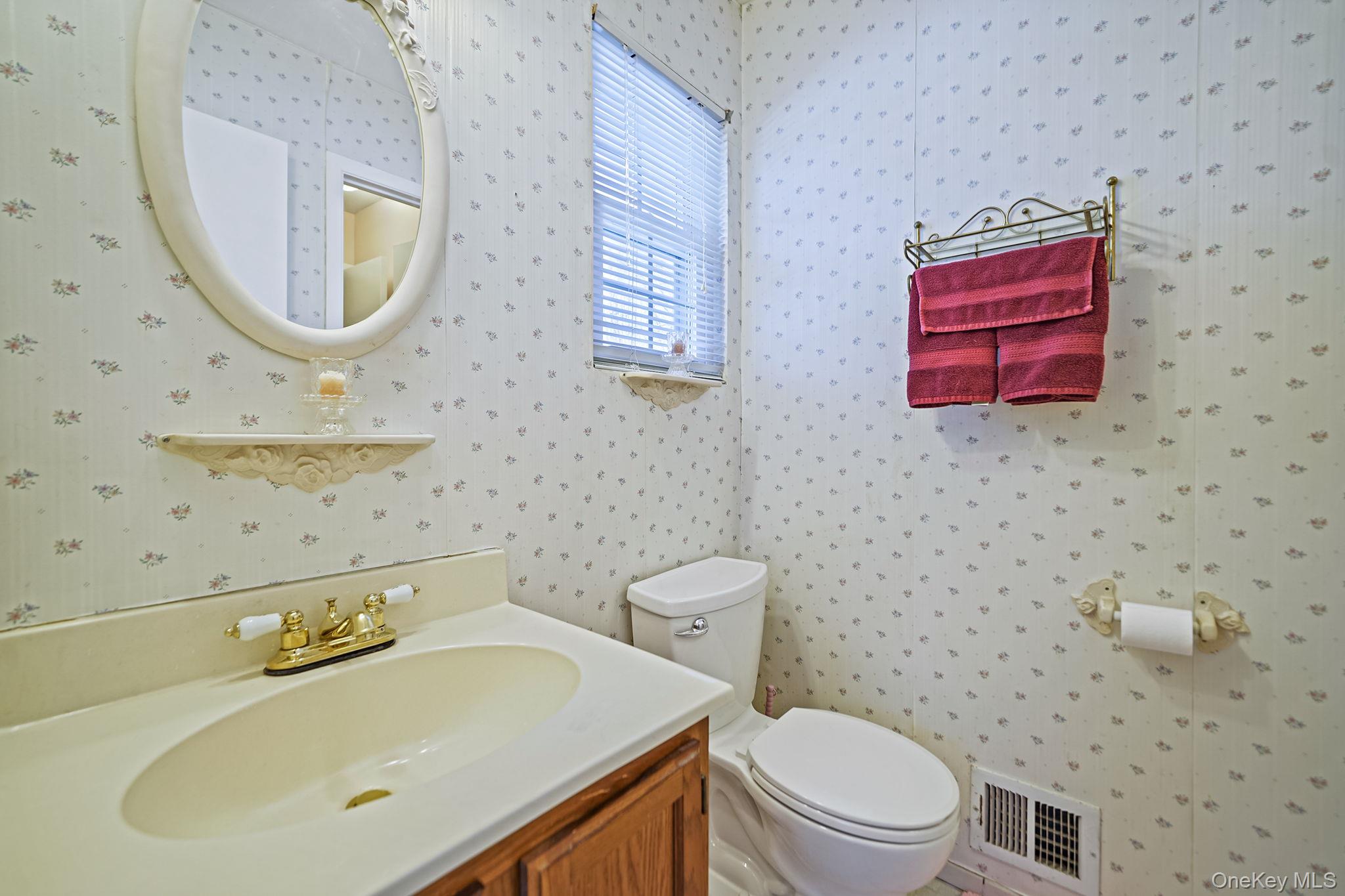8 Huntington Commons, Unit 8 Yaphank, NY 11980 - Photo 23 of 30 a bathroom with a sink a mirror and a toilet
