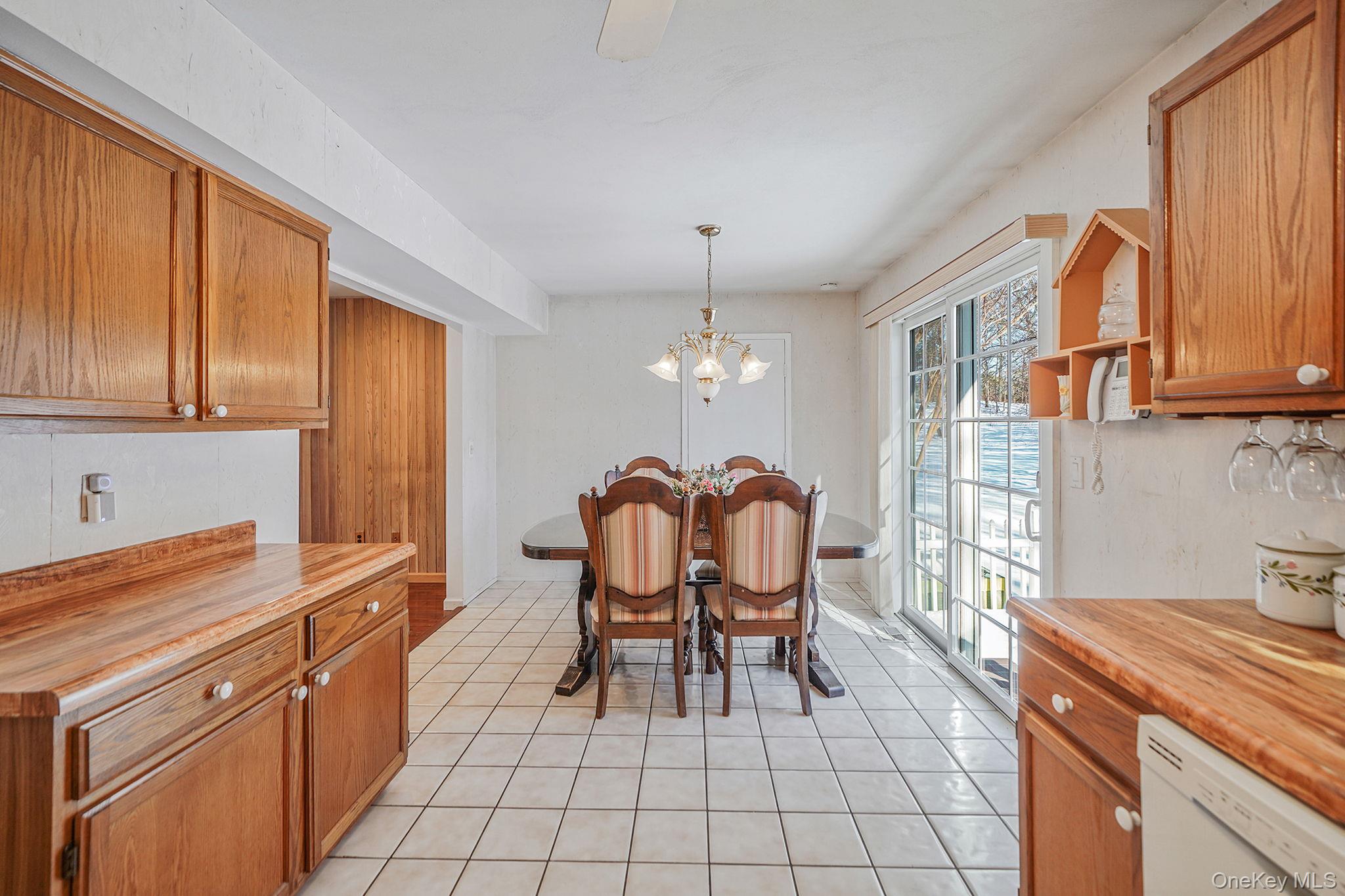 8 Huntington Commons, Unit 8 Yaphank, NY 11980 - Photo 25 of 30 a kitchen with granite countertop cabinets a dining table and chairs