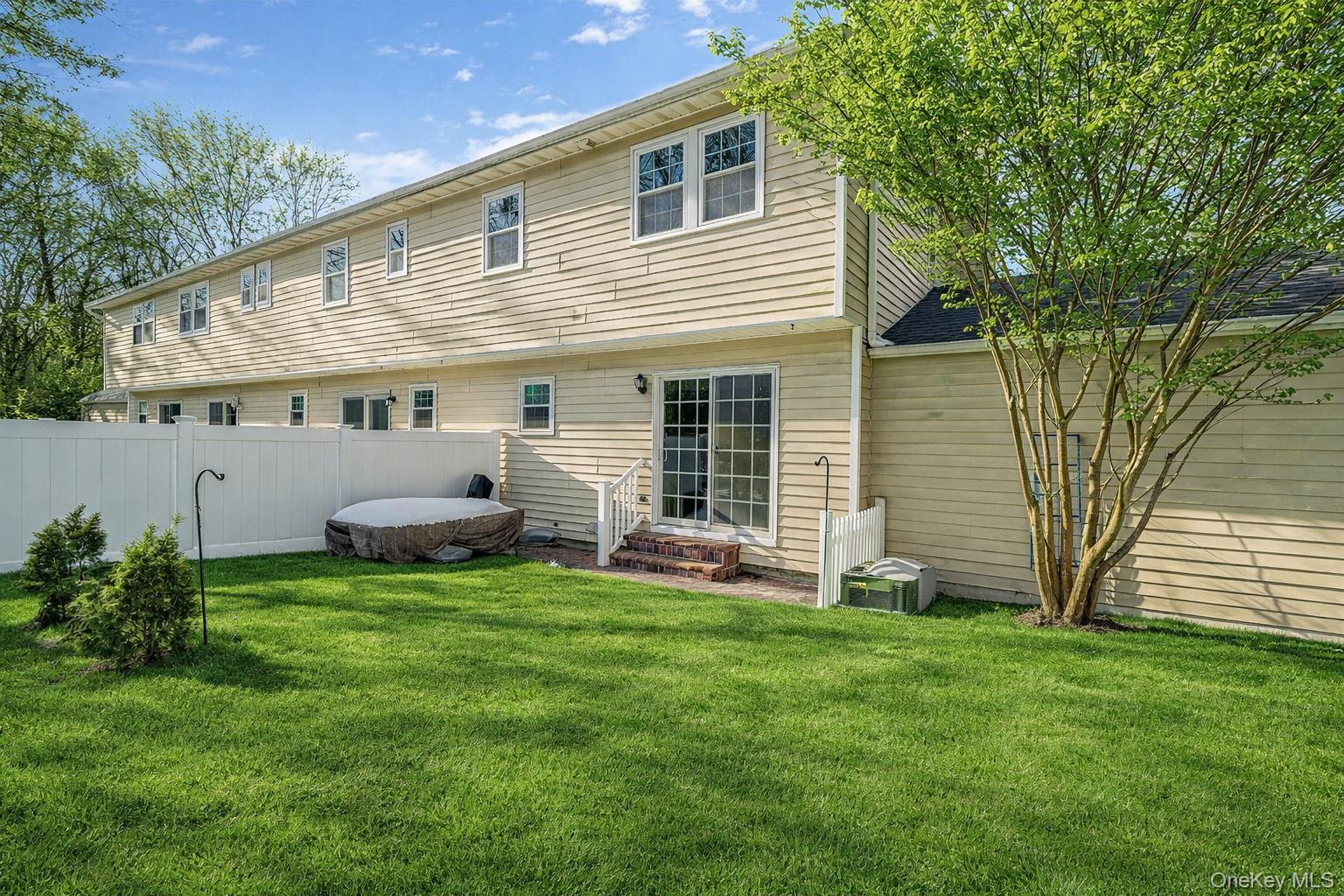 8 Huntington Commons, Unit 8 Yaphank, NY 11980 - Photo 30 of 30 a view of a house with a backyard