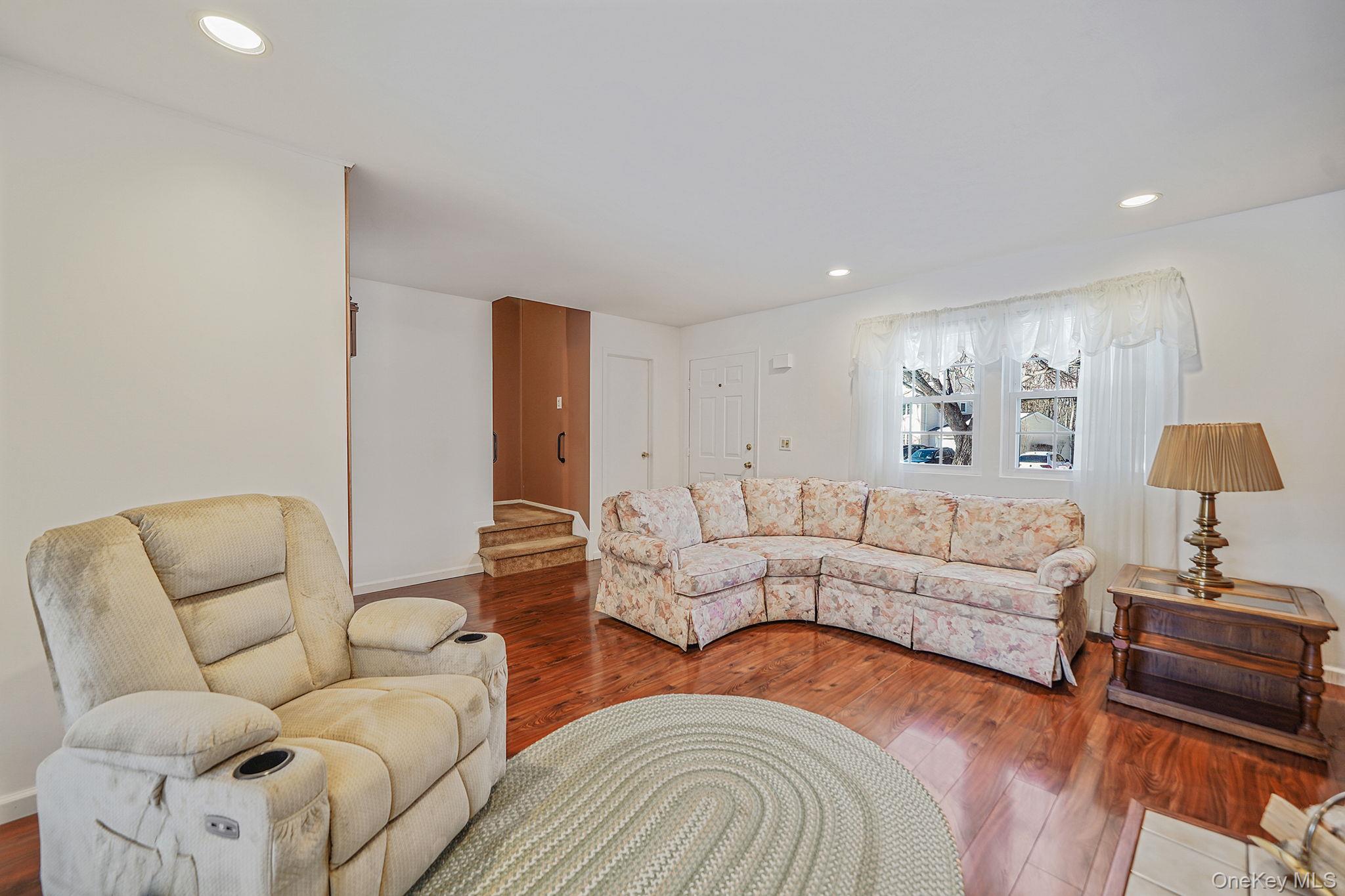 8 Huntington Commons, Unit 8 Yaphank, NY 11980 - Photo 5 of 30 a living room with furniture and a lamp