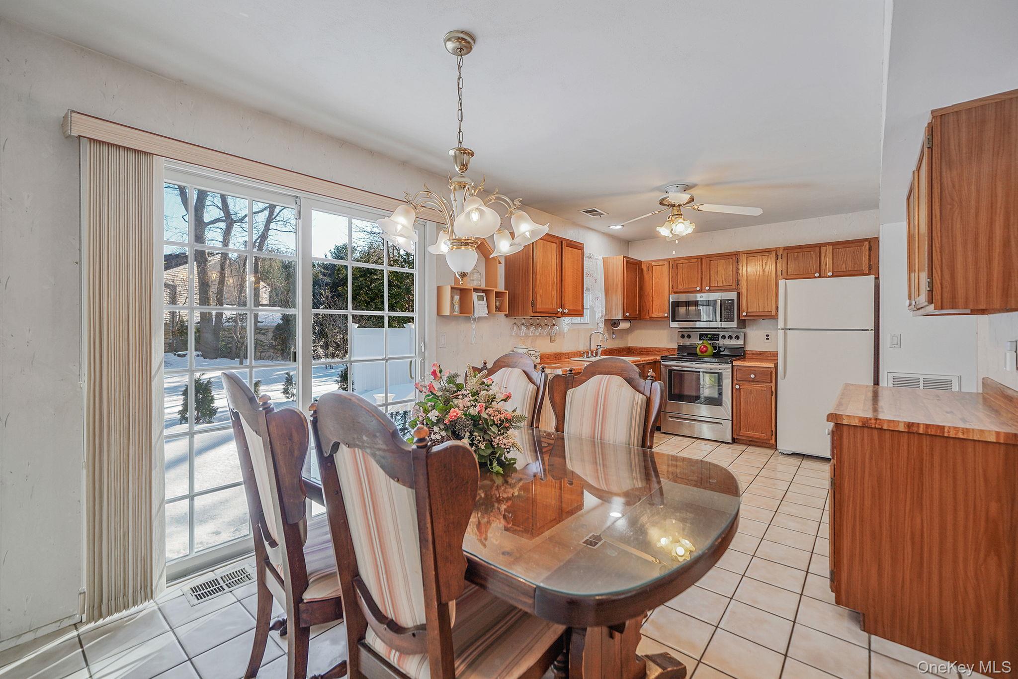8 Huntington Commons, Unit 8 Yaphank, NY 11980 - Photo 6 of 30 a dining room filled chandelier and wooden furniture