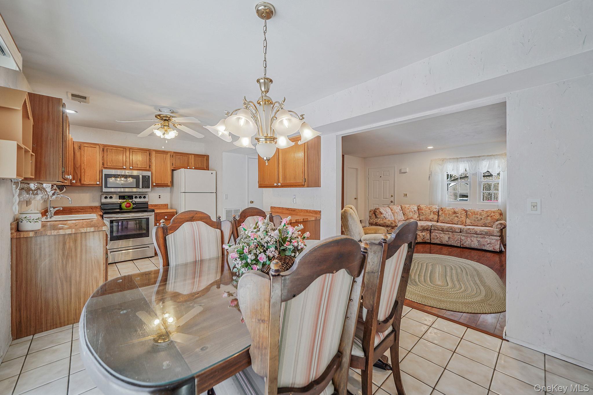 8 Huntington Commons, Unit 8 Yaphank, NY 11980 - Photo 7 of 30 a dining room filled chandelier and kitchen view