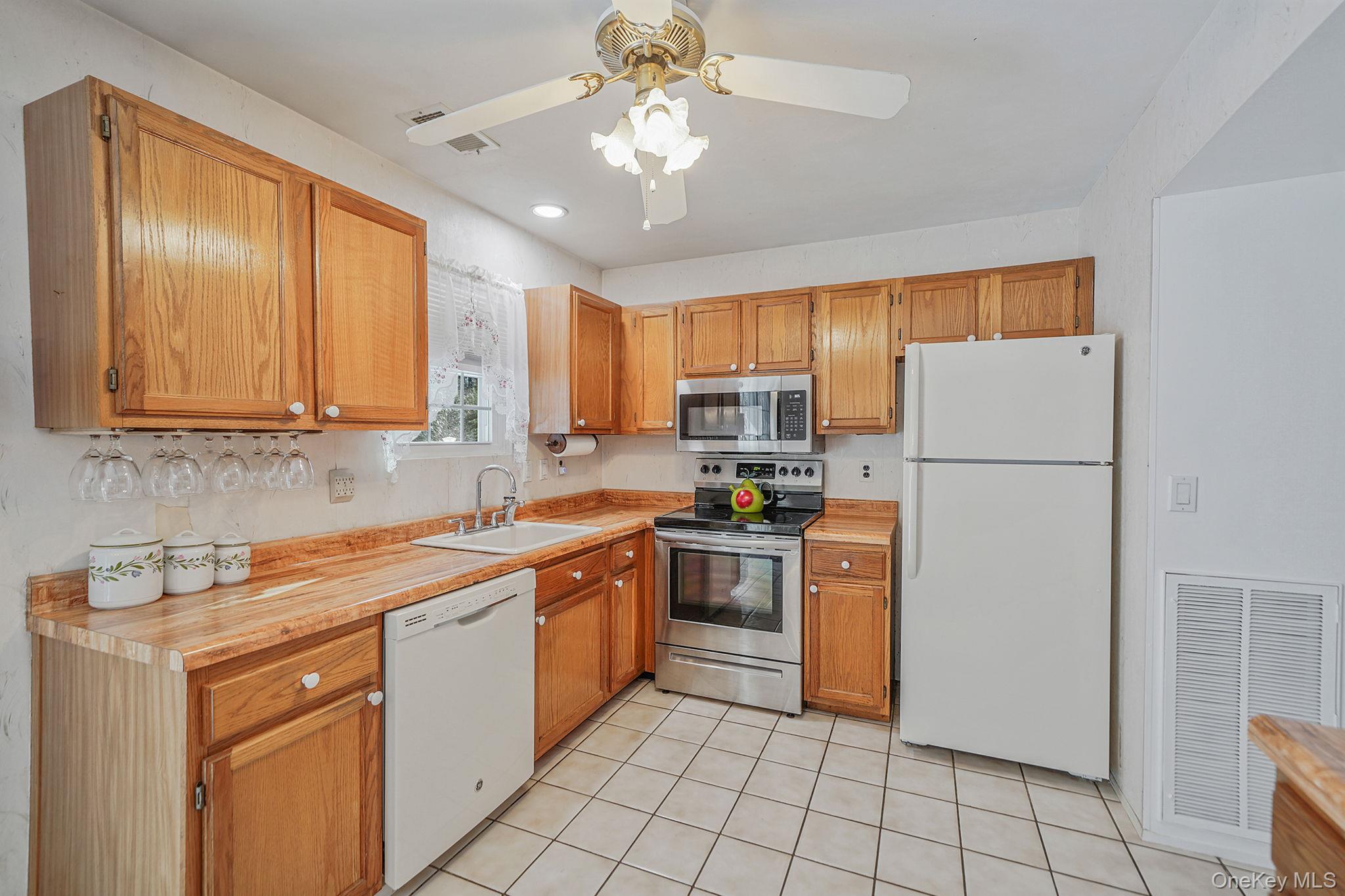 8 Huntington Commons, Unit 8 Yaphank, NY 11980 - Photo 8 of 30 a kitchen with stainless steel appliances granite countertop a refrigerator sink and stove