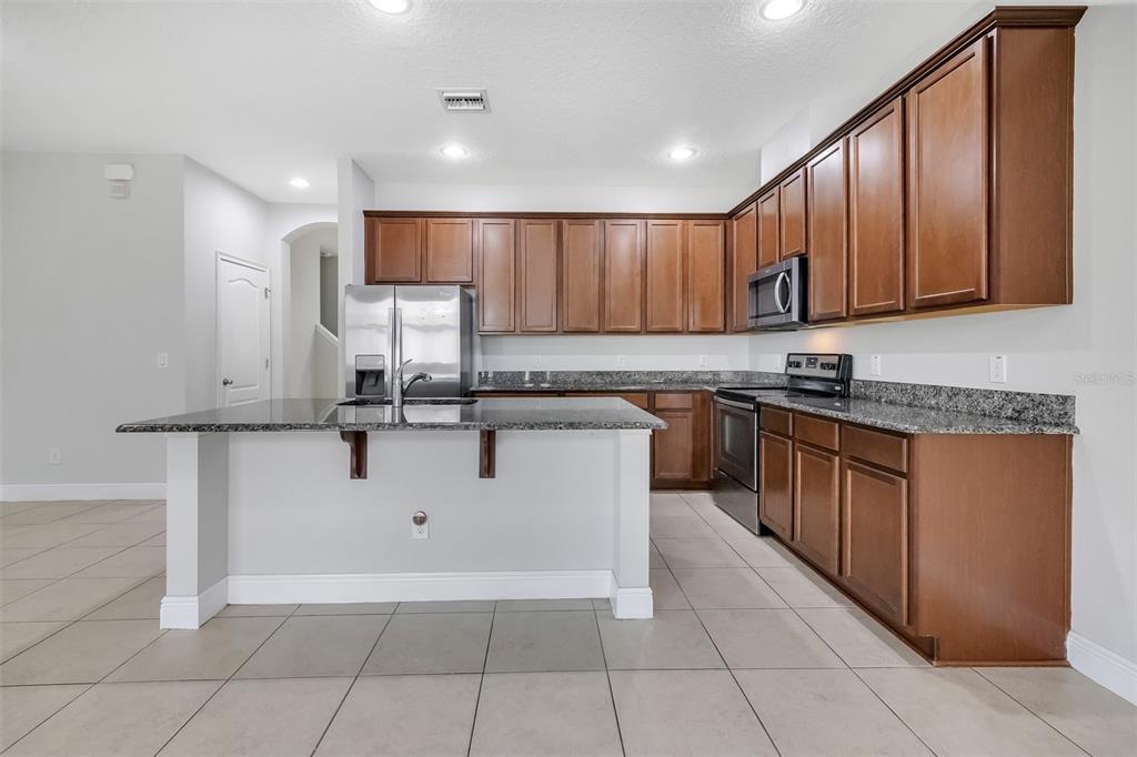 12357 Via Derna Place Windermere, FL 34786 - Photo 12 of 33 a large kitchen with stainless steel appliances granite countertop a stove a sink dishwasher and a refrigerator