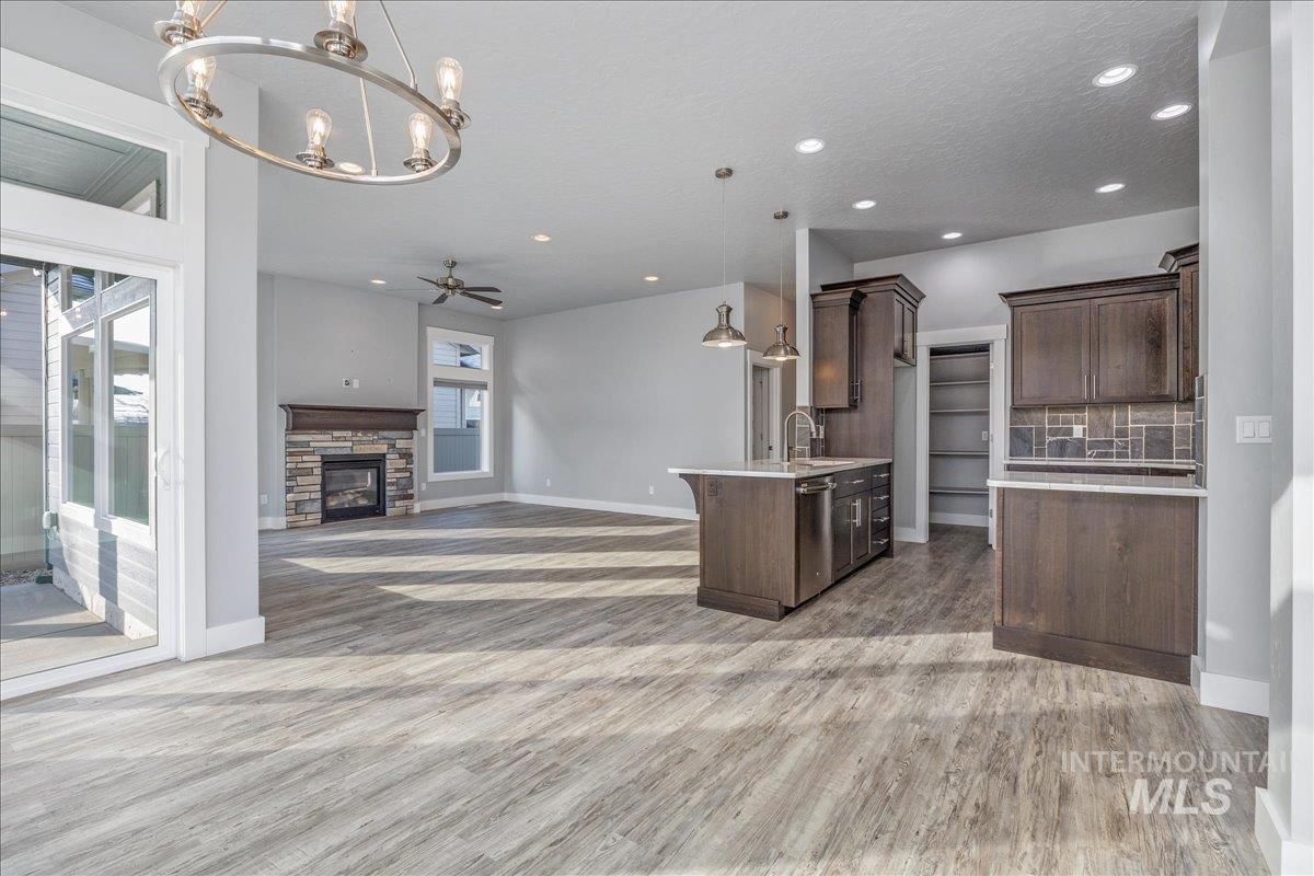 3036 Northwest 13th Street Meridian, ID 83646 - Photo 50 of 50 Kitchen featuring open floor plan, ceiling fan, dark wood finish cabinets, and a fireplace