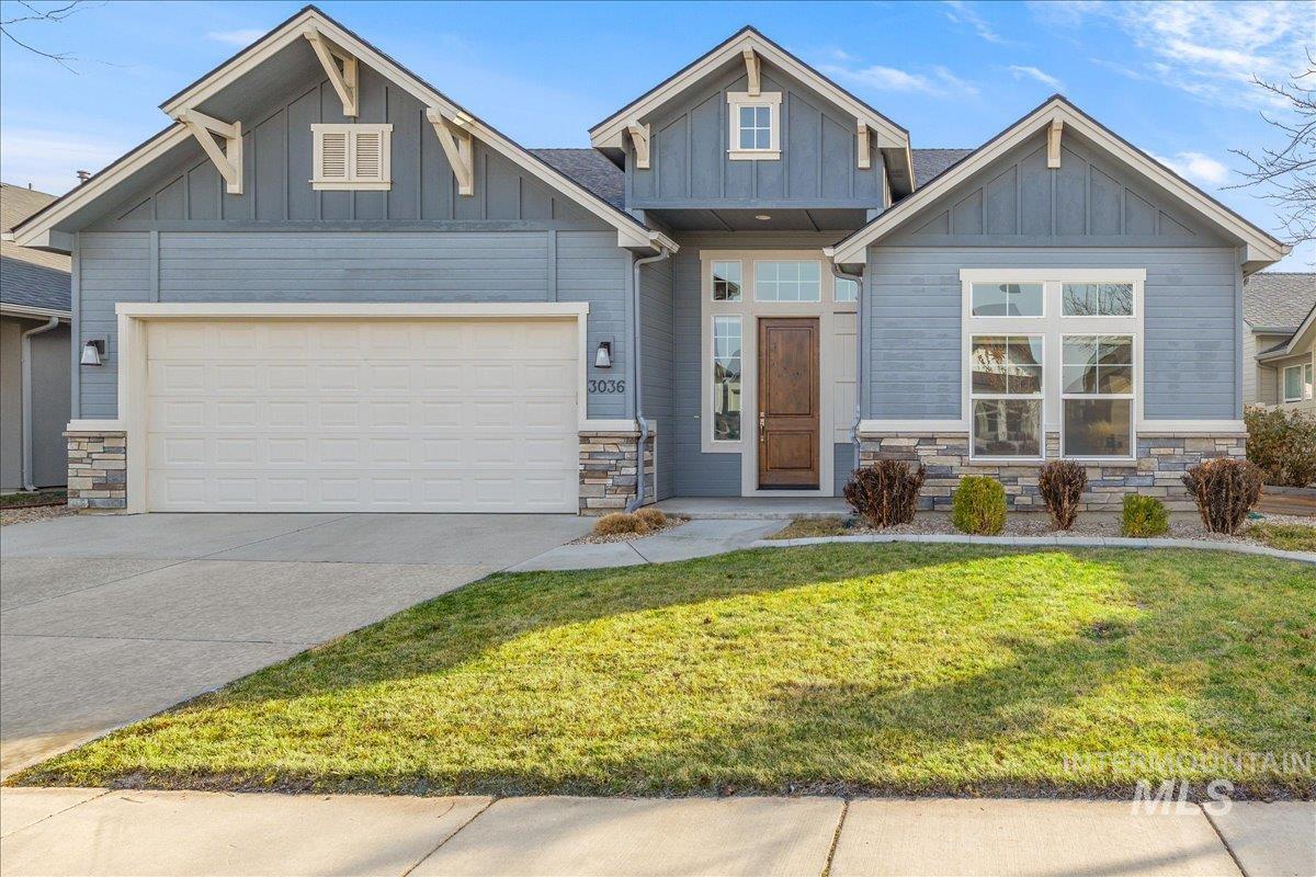 3036 Northwest 13th Street Meridian, ID 83646 - Photo 2 of 50 Craftsman house with stone siding, board and batten siding, a front lawn, and driveway