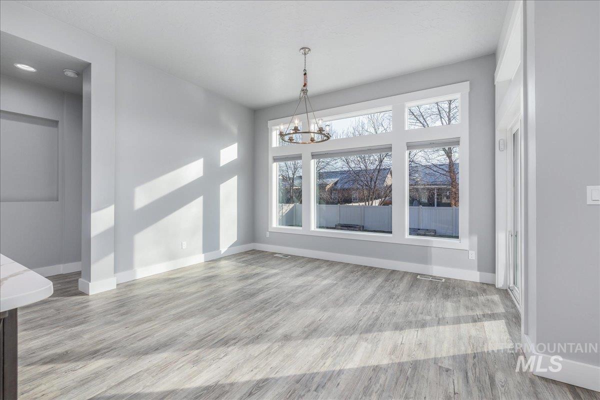 3036 Northwest 13th Street Meridian, ID 83646 - Photo 21 of 50 Unfurnished dining area featuring light wood-type flooring and a chandelier