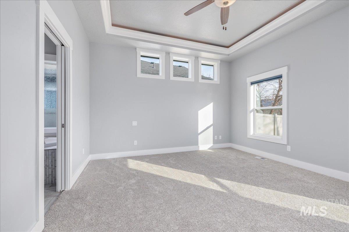 3036 Northwest 13th Street Meridian, ID 83646 - Photo 23 of 50 Empty room with light colored carpet, a tray ceiling, and ceiling fan