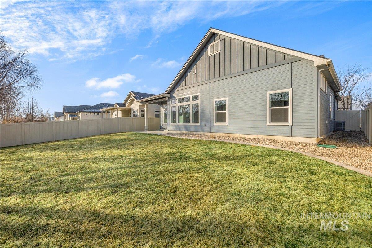 3036 Northwest 13th Street Meridian, ID 83646 - Photo 42 of 50 Rear view of house with a fenced backyard and board and batten siding