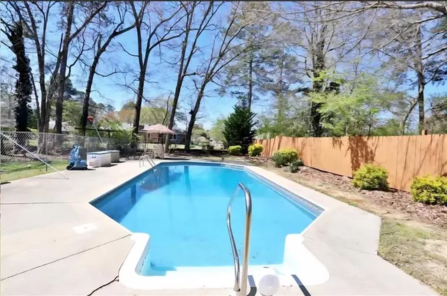 a swimming pool with outdoor seating and yard