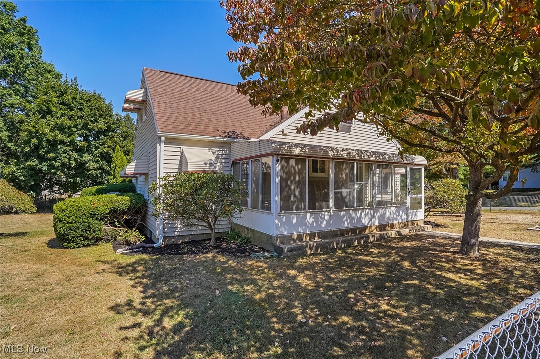 2809 McElwain Road Akron, OH 44312 - Photo 2 of 38 Front of property featuring a sunroom, roof with shingles, and a yard