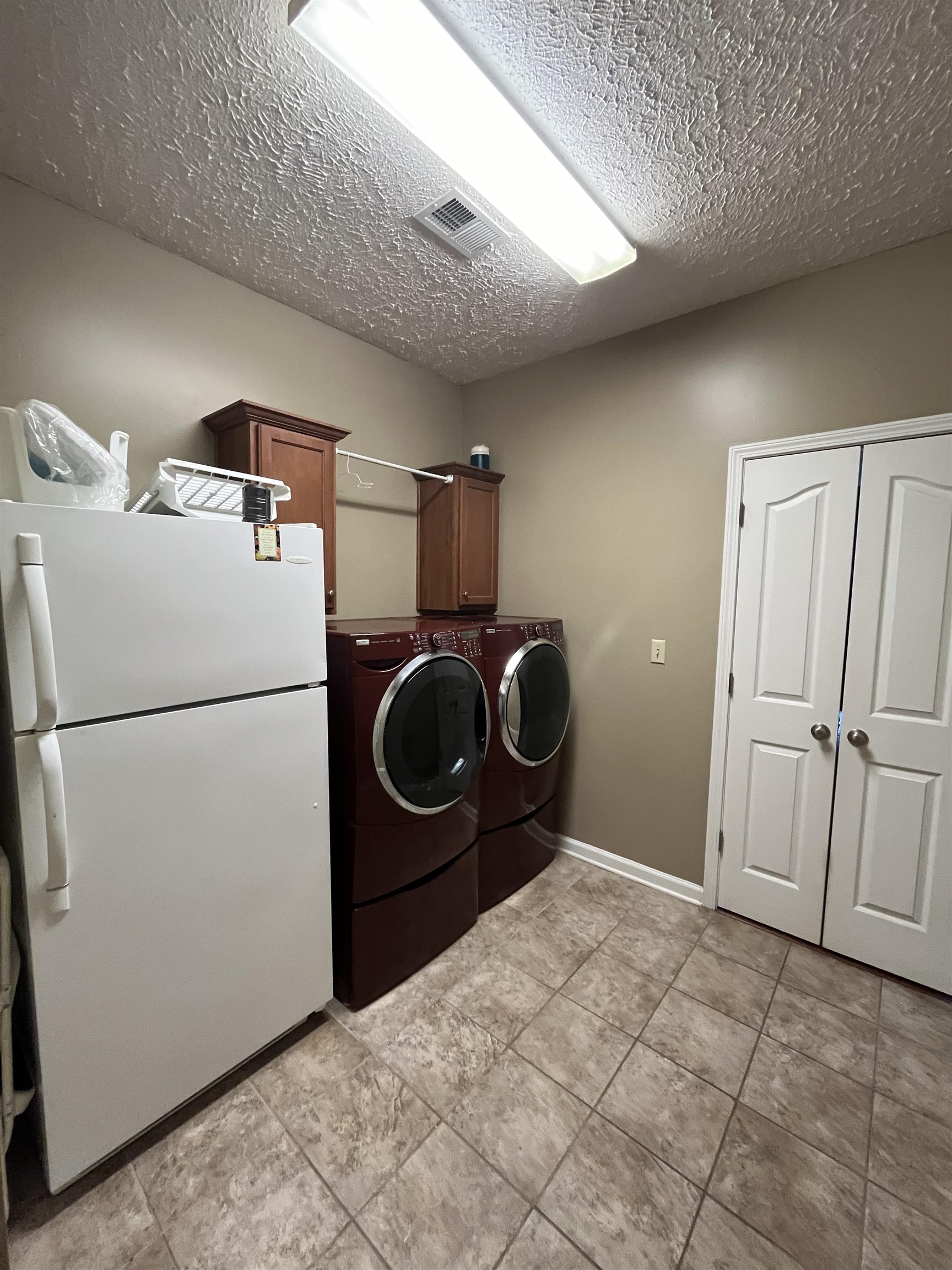 5485 Shipp Road Millington, TN 38053 - Photo 14 of 17 Washroom with light tile patterned flooring, separate washer and dryer, cabinets, and a textured ceiling