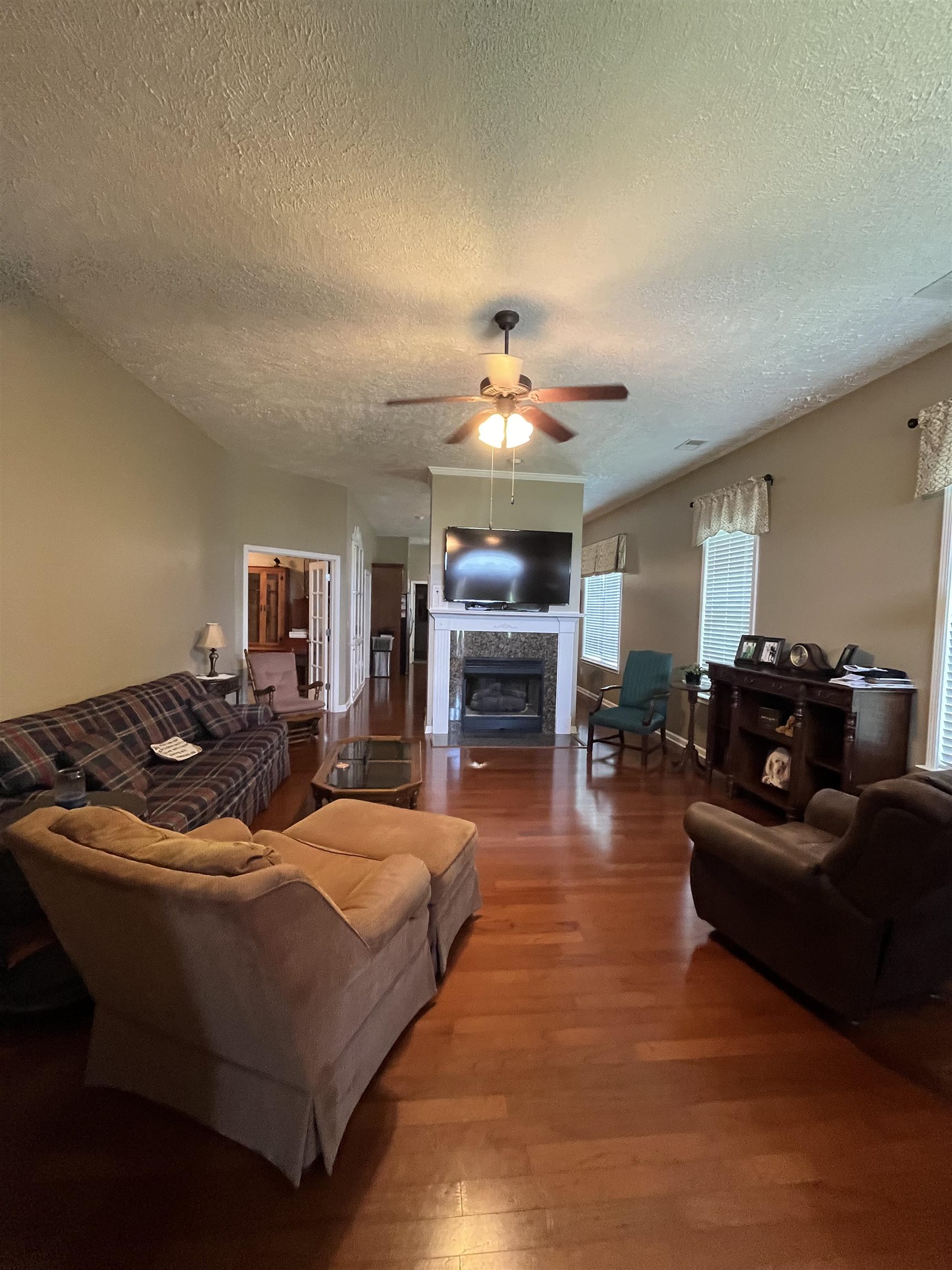 5485 Shipp Road Millington, TN 38053 - Photo 3 of 17 Living room with a textured ceiling, ceiling fan, and hardwood / wood-style floors