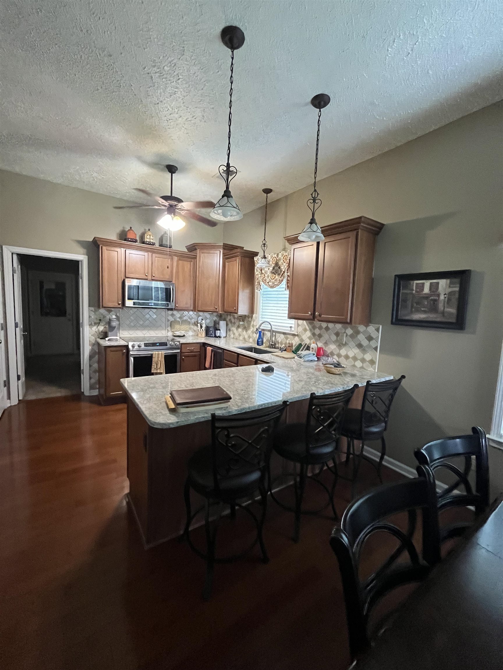 5485 Shipp Road Millington, TN 38053 - Photo 5 of 17 Kitchen with dark hardwood / wood-style floors, stainless steel appliances, tasteful backsplash, and kitchen peninsula