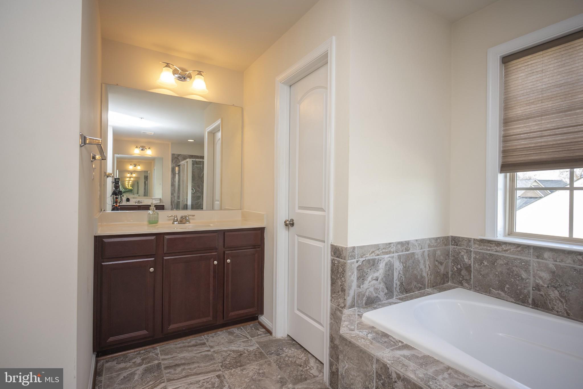 2703 Swann Wing Court Lanham, MD 20706 - Photo 22 of 36 a bathroom with a tub sink and mirror