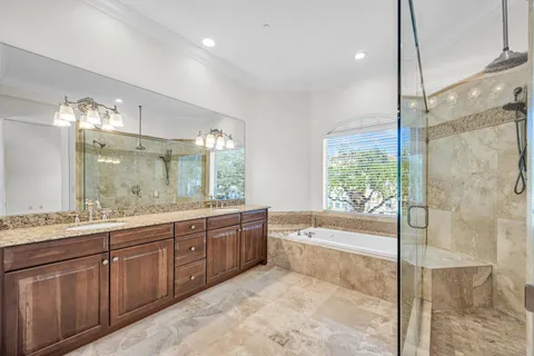 a bathroom with a tub sink shower and mirror