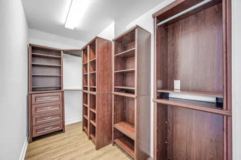a view of walk in closet with empty racks