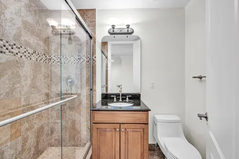 a bathroom with a sink a toilet and shower