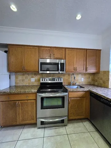 a kitchen with a sink and a stove top oven
