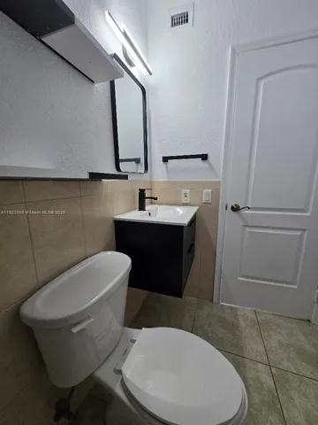 a bathroom with a toilet a sink and mirror