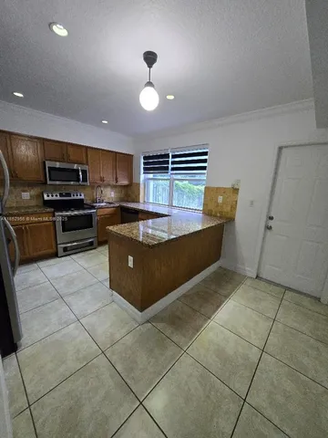 a kitchen with stainless steel appliances a stove a sink a microwave and a refrigerator