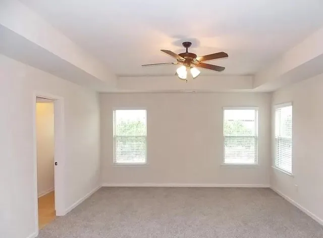 a view of a room with a ceiling fan and a window