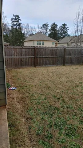a view of a yard with a wooden fence