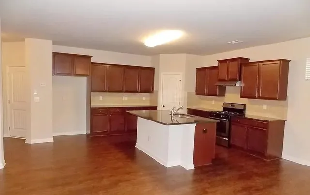 a kitchen with stainless steel appliances granite countertop a stove top oven a sink and dishwasher