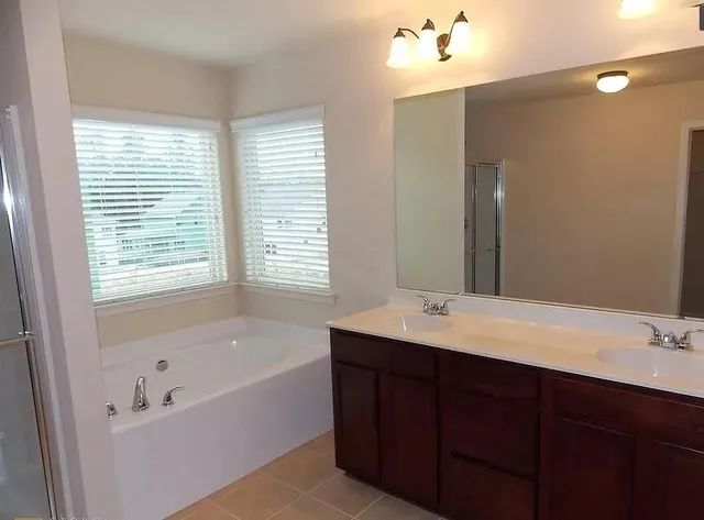 a bathroom with a tub sink and mirror