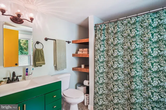 a bathroom with a granite countertop toilet sink and mirror