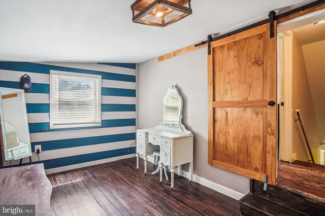 a view of a bedroom with wooden floor and windows