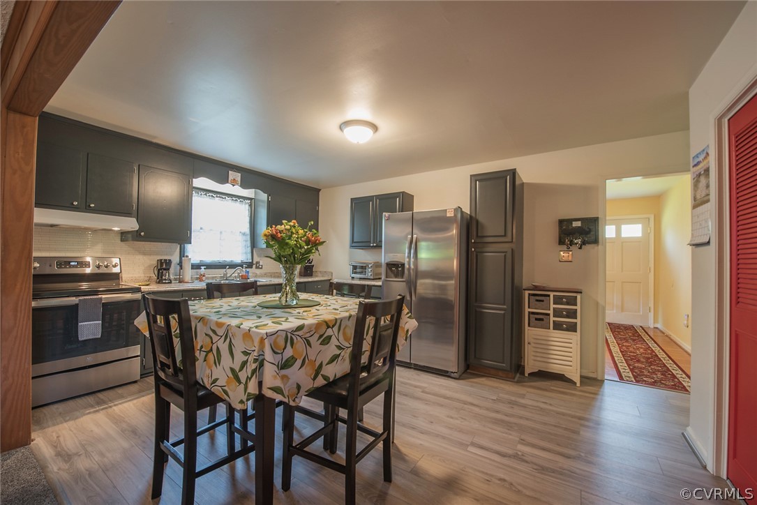 15501 Saddlebrook Road Chesterfield, VA 23838 - Photo 11 of 44 a kitchen with stainless steel appliances a refrigerator a stove a sink dishwasher a dining table and chairs with wooden floor