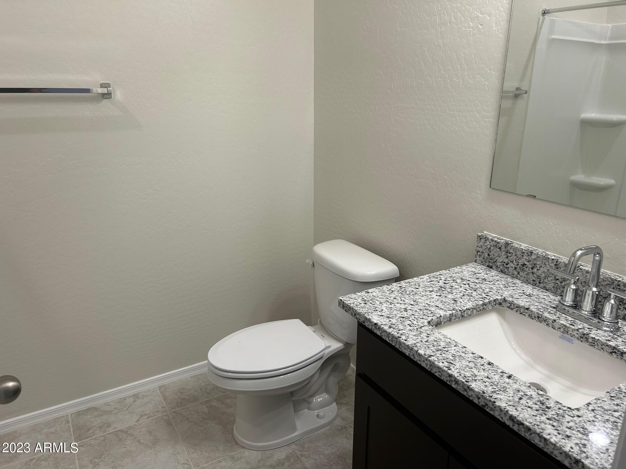 5119 East Emery Road San Tan Valley, AZ 85143 - Photo 14 of 19 a bathroom with a granite countertop toilet and sink