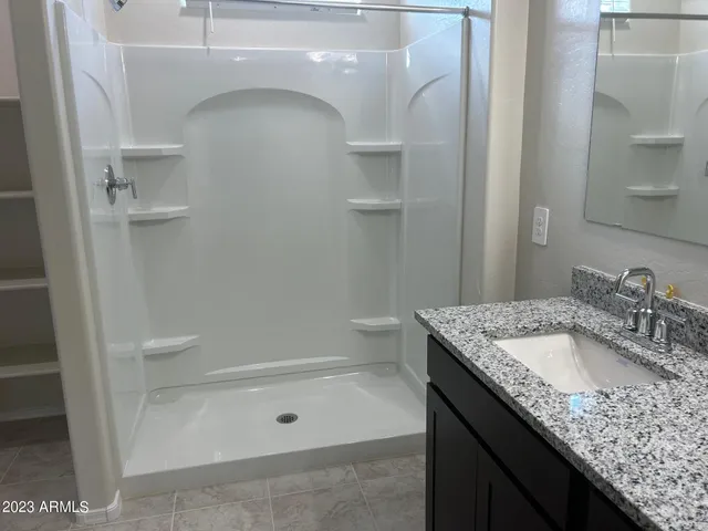 a bathroom with a granite countertop sink a toilet and shower