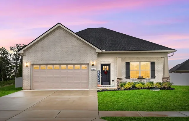 a front view of a house with a garden and yard