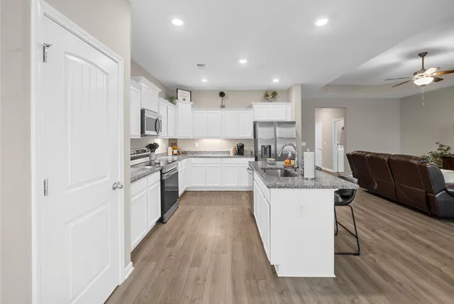 a kitchen with counter top space a sink cabinets and stainless steel appliances