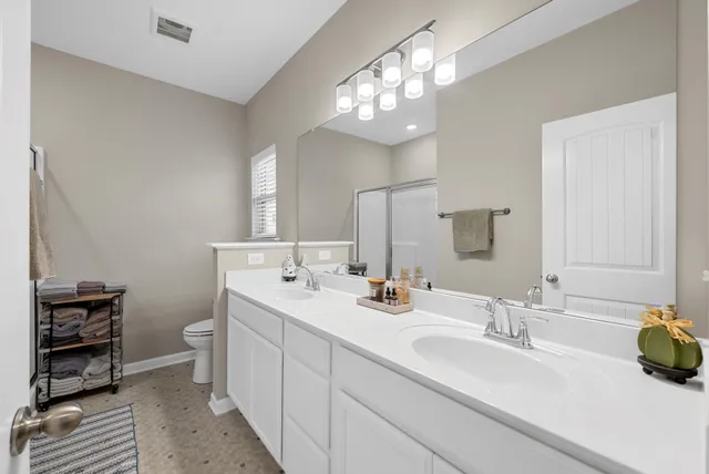 a bathroom with a double vanity sink and a toilet