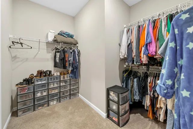 a view of walk in closet with clothes and shoes